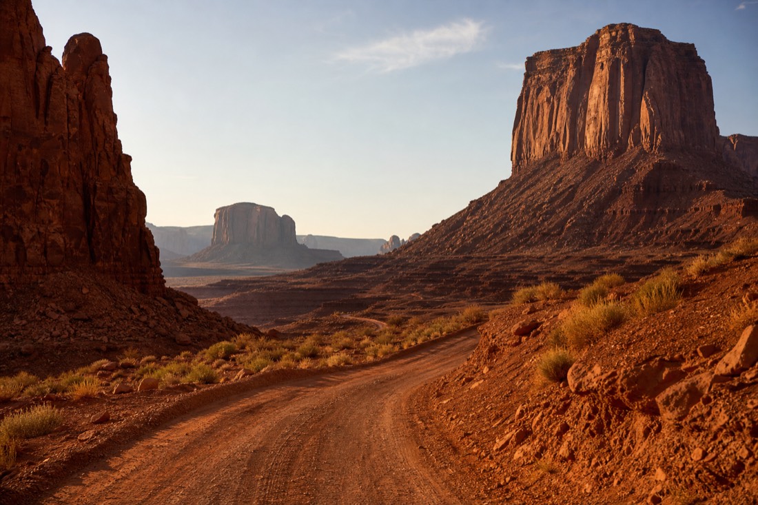 The 17-mile Valley Drive dirt road winding between towering buttes and Merrick Butte under a low sun