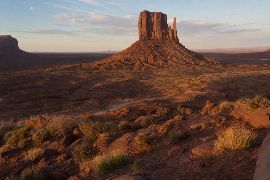 Golden-hour light raking across Merrick Butte and the open red valley floor