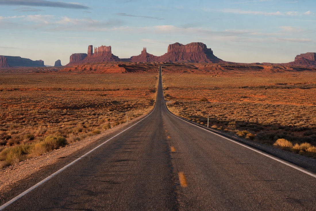 The straight US-163 highway at Forrest Gump Point running dead into the distant buttes under an open sky