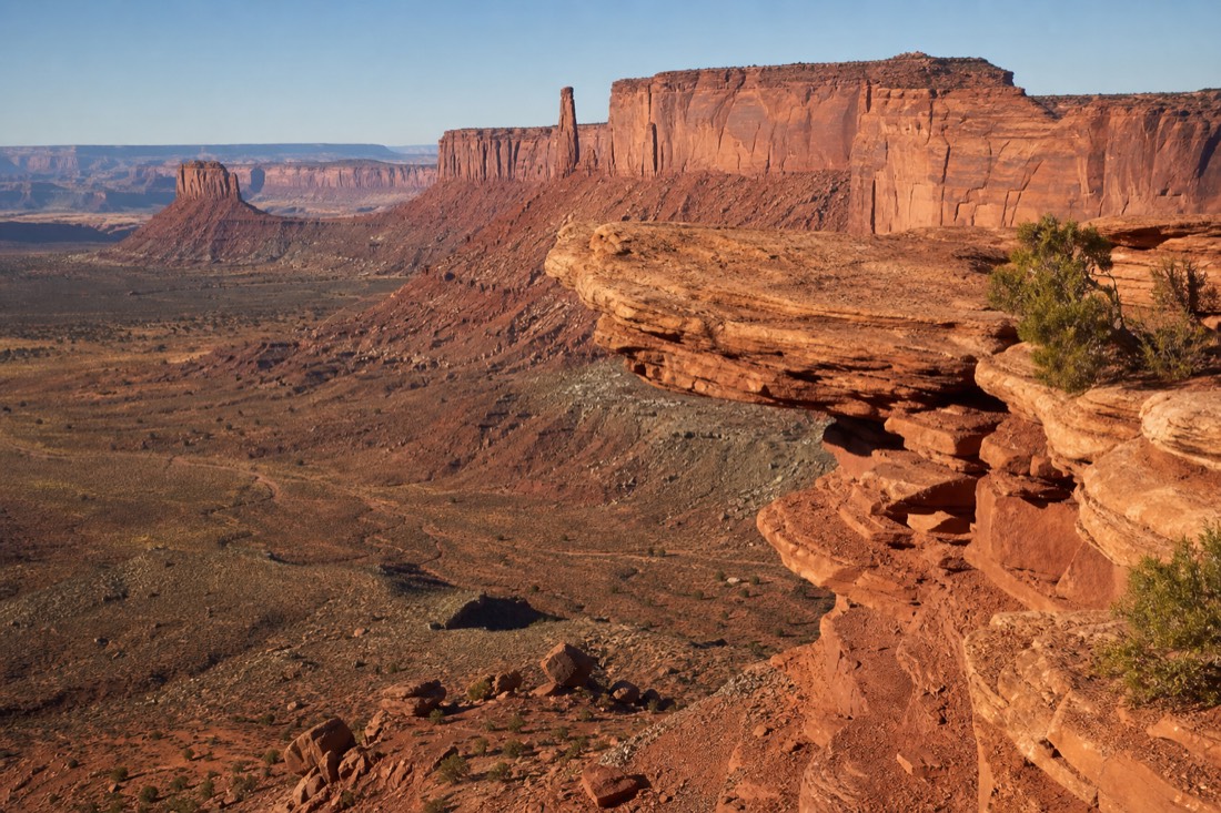 John Ford Point promontory jutting over the valley floor with red buttes behind at a marked overlook
