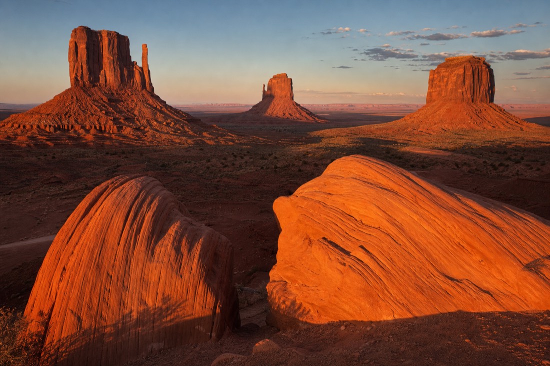 The Mittens at sunset with warm side-light and long shadows across red sandstone
