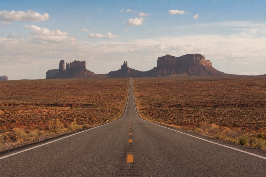 Forrest Gump Point on US-163 with the empty highway vanishing toward the buttes