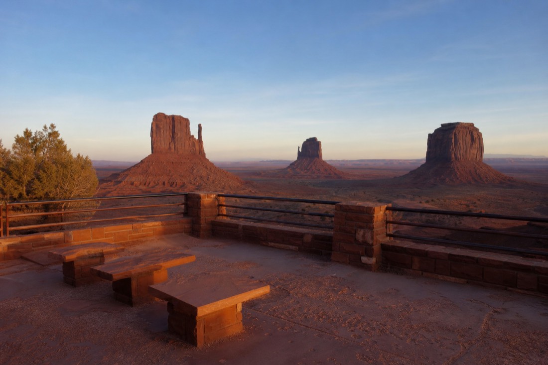 Level terrace viewpoint with seating and a railing looking out over the buttes