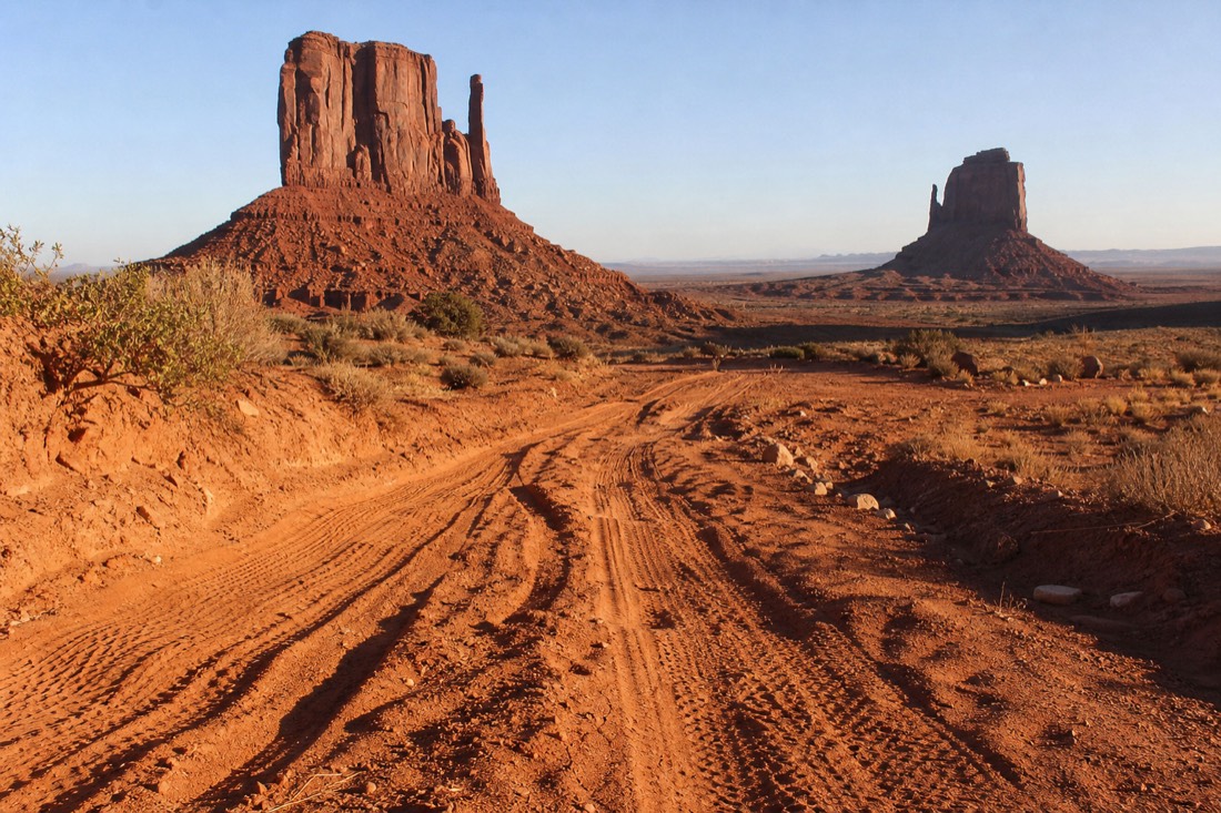 Deep washboard ruts and loose red sand on the rough loop road running between two sandstone buttes