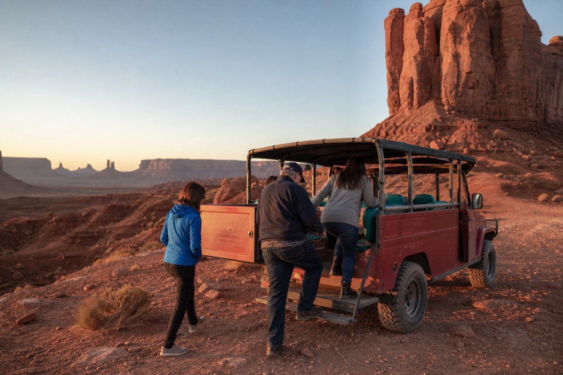 A small group boarding an open-air Navajo jeep at John Ford Point for a guided valley tour