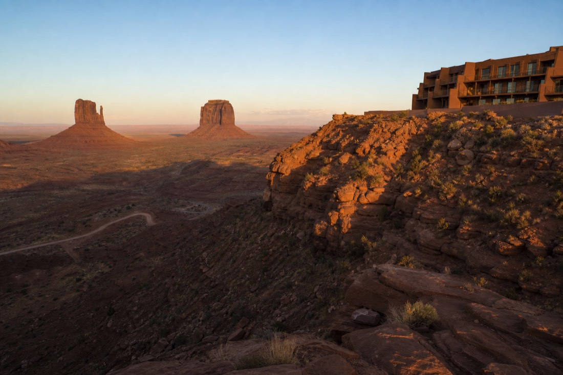 The View-style lodge silhouette on the mesa rim, room balconies facing the two Mitten buttes at first light
