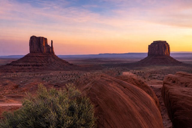 First light of sunrise on the Mitten Buttes in Monument Valley, cool pink and gold sky